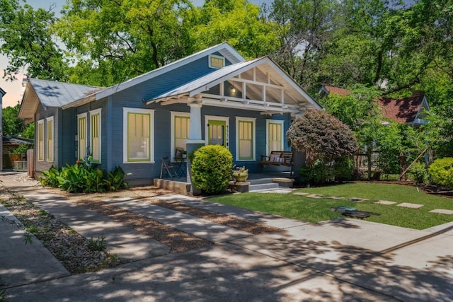 4536 Duval St Unit 2, Austin, TX 78751 - view of front of home with covered porch, a front lawn, and metal roof