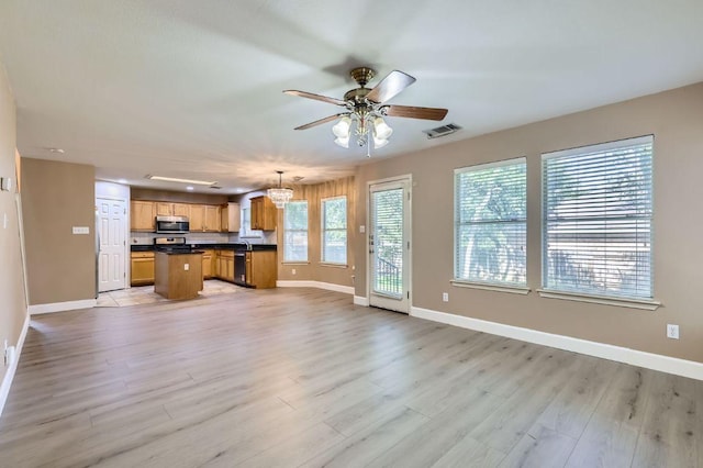 10517 S Canoa Hills Trl, Austin, TX 78717 - kitchen with open floor plan, dark countertops, ceiling fan, light wood-style flooring, and a chandelier