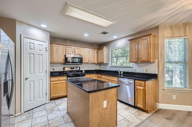 10517 S Canoa Hills Trl, Austin, TX 78717 - kitchen with stainless steel appliances, a sink, a center island, backsplash, and dark stone counters