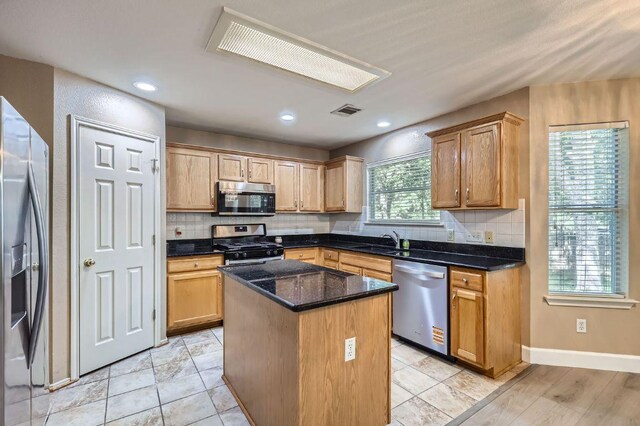 10517 S Canoa Hills Trl, Austin, TX 78717 - kitchen featuring appliances with stainless steel finishes, a center island, backsplash, dark stone countertops, and recessed lighting