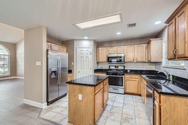 10517 S Canoa Hills Trl, Austin, TX 78717 - kitchen with appliances with stainless steel finishes, a sink, a center island, decorative backsplash, and baseboards
