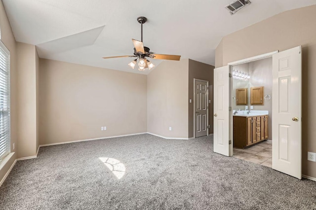 10517 S Canoa Hills Trl, Austin, TX 78717 - unfurnished bedroom with light colored carpet, multiple windows, lofted ceiling, ensuite bathroom, and ceiling fan