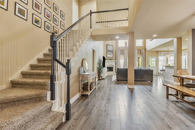 607 Westbury Ln, Georgetown, TX 78633 - foyer entrance with a fireplace, wood finished floors, stairs, and a towering ceiling