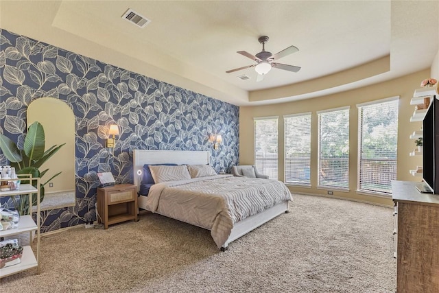 607 Westbury Ln, Georgetown, TX 78633 - bedroom featuring wallpapered walls, a raised ceiling, carpet, an accent wall, and ceiling fan