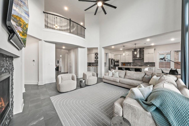124 Low River Ln, Georgetown, TX 78628 - living area featuring a brick fireplace, ceiling fan, a towering ceiling, recessed lighting, and baseboards