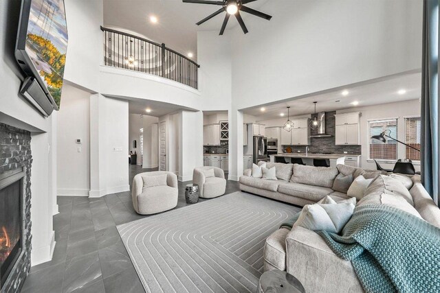 124 Low River Ln, Georgetown, TX 78628 - living area with a brick fireplace, a ceiling fan, a towering ceiling, and recessed lighting