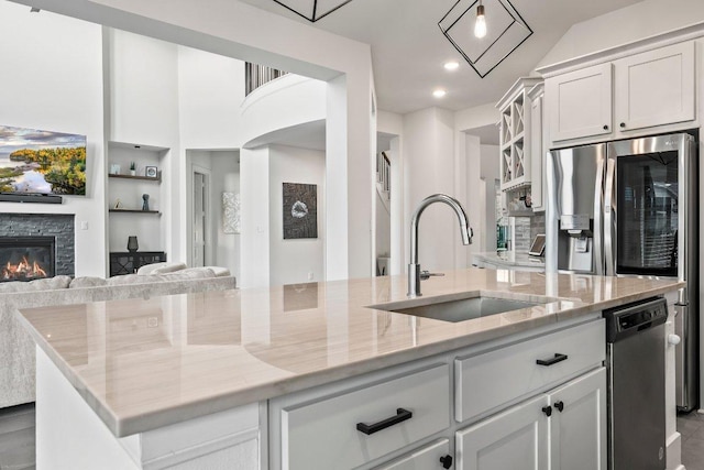 124 Low River Ln, Georgetown, TX 78628 - kitchen featuring a sink, open floor plan, an island with sink, white cabinets, and light stone countertops