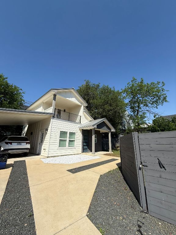 view of property exterior with concrete driveway and an attached carport