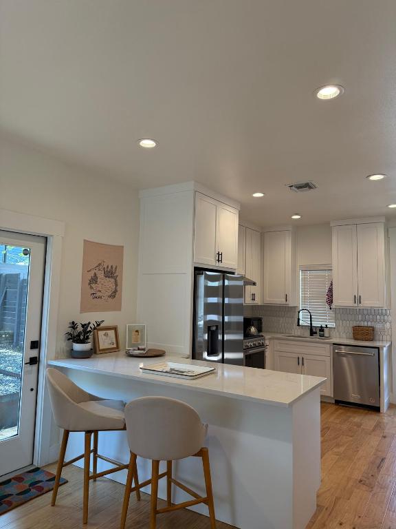 806 Philco Dr Unit 2, Austin, TX 78745 - kitchen featuring appliances with stainless steel finishes, a sink, white cabinets, light countertops, and decorative backsplash