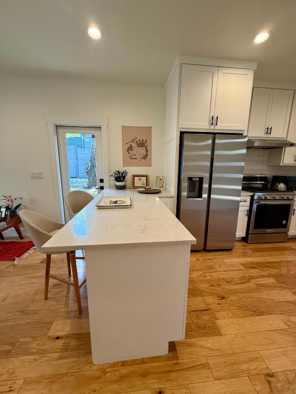 kitchen with stainless steel appliances, under cabinet range hood, white cabinets, decorative backsplash, and recessed lighting
