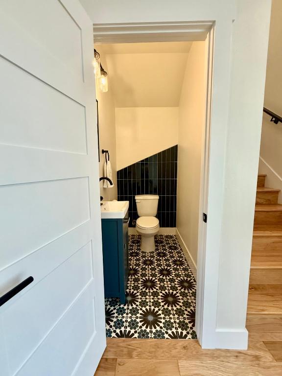 half bath with toilet, tile walls, and vanity