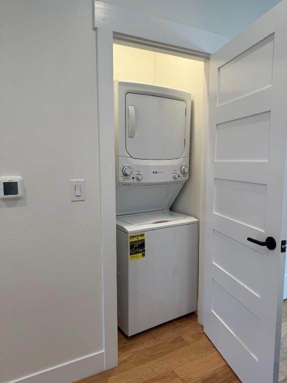 806 Philco Dr Unit 2, Austin, TX 78745 - washroom with stacked washing machine and dryer and light wood-type flooring