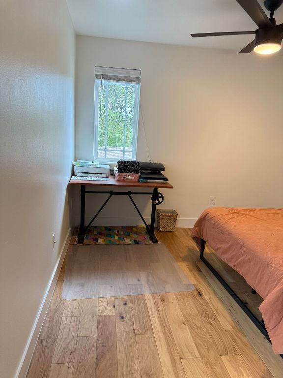bedroom featuring wood finished floors, baseboards, and ceiling fan