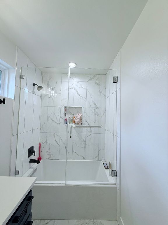 bathroom with washtub / shower combination and vanity
