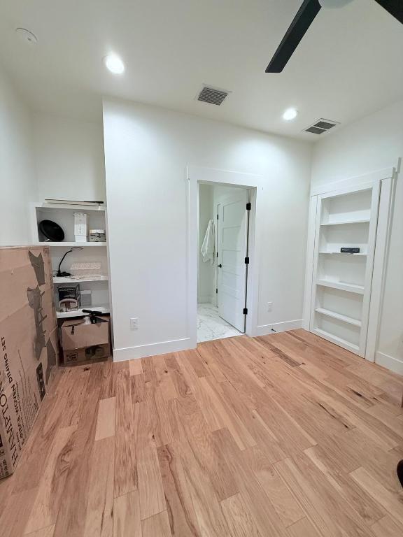 unfurnished bedroom featuring wood finished floors, baseboards, and recessed lighting