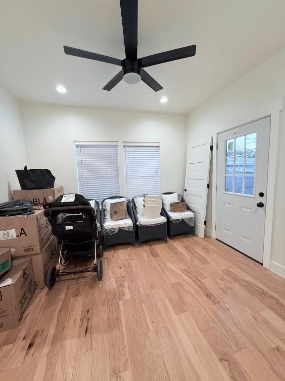interior space with light wood-style flooring, a ceiling fan, and recessed lighting