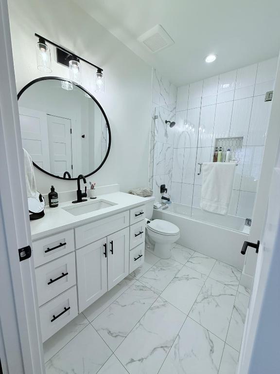 806 Philco Dr Unit 2, Austin, TX 78745 - bathroom featuring vanity, toilet, bathtub / shower combination, marble look tile flooring, and recessed lighting