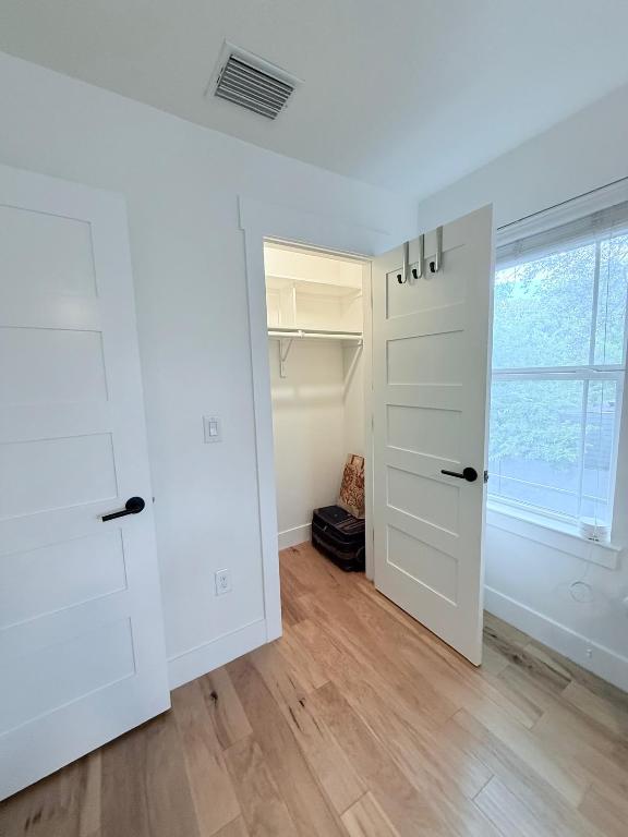 806 Philco Dr Unit 2, Austin, TX 78745 - unfurnished bedroom featuring light wood-style flooring, baseboards, a closet, and a spacious closet