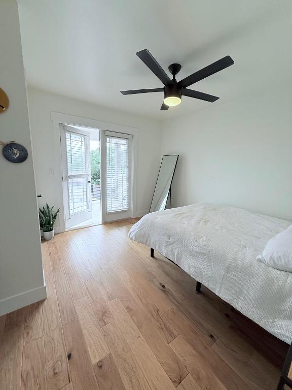 806 Philco Dr Unit 2, Austin, TX 78745 - bedroom with access to exterior, wood finished floors, baseboards, and ceiling fan