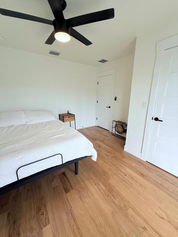 bedroom featuring light wood finished floors, ceiling fan, and baseboards