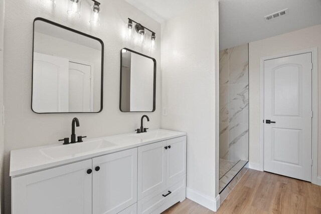 13221 Cabinet Dr, Manor, TX 78653 - full bathroom featuring wood finished floors, a marble finish shower, and double vanity