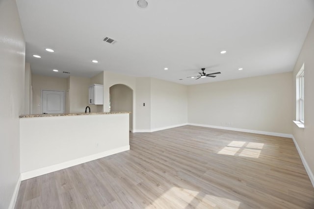 13221 Cabinet Dr, Manor, TX 78653 - unfurnished living room with light wood-style floors, recessed lighting, arched walkways, and ceiling fan