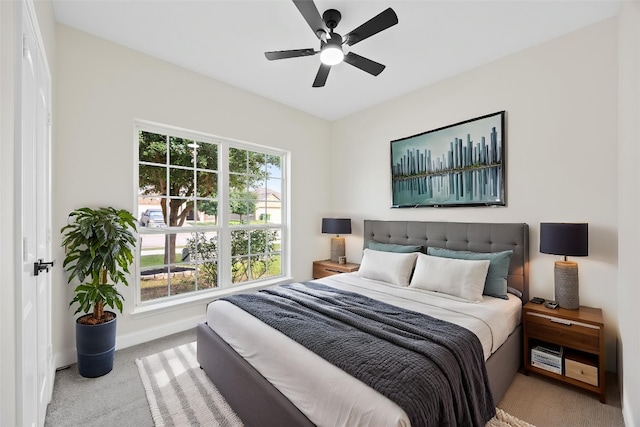 carpeted bedroom featuring baseboards and ceiling fan