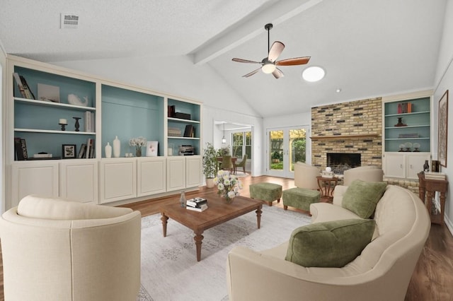 living room featuring wood finished floors, ceiling fan, a brick fireplace, a textured ceiling, and built in features