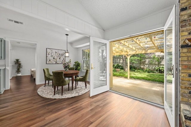 12025 Wycliff Ln, Austin, TX 78727 - dining room featuring wood finished floors, vaulted ceiling, and a textured ceiling