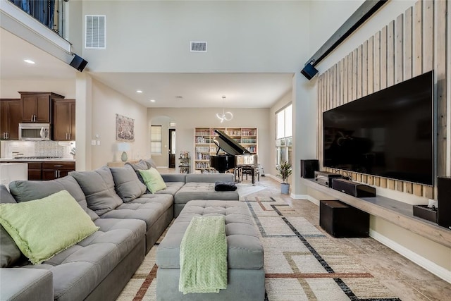 402 Dry Gulch Bnd, Cedar Park, TX 78613 - living room featuring a high ceiling, arched walkways, baseboards, and recessed lighting