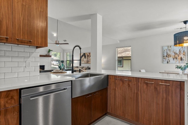 kitchen with dishwasher, a sink, light countertops, a ceiling fan, and a lit fireplace