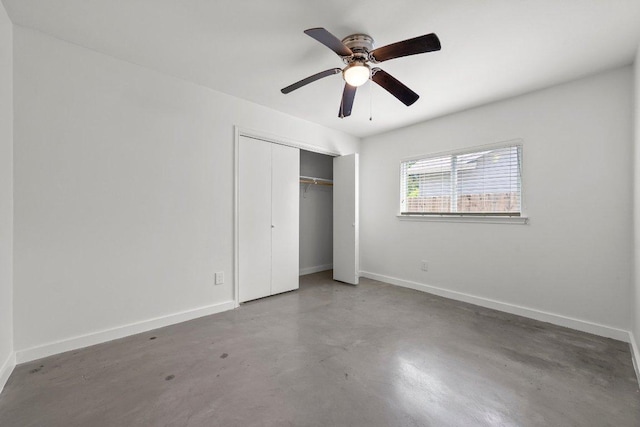 unfurnished bedroom featuring finished concrete flooring, baseboards, a closet, and a ceiling fan