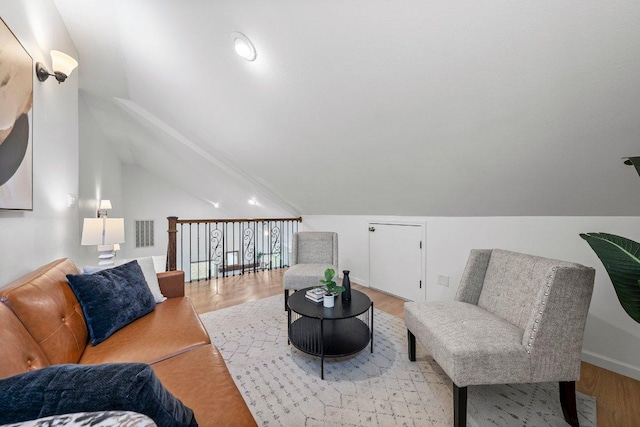 living area with vaulted ceiling and wood finished floors