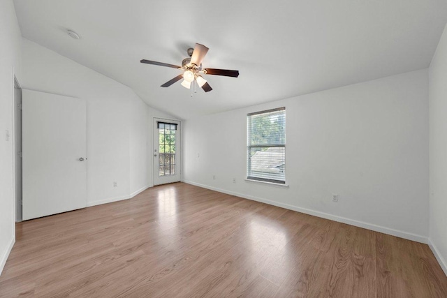 unfurnished room with lofted ceiling, a ceiling fan, light wood-style flooring, and baseboards