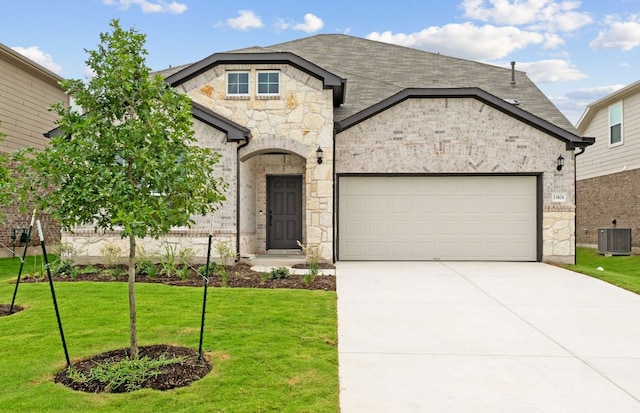 13404 Lapoynor St, Manor, TX 78653 - french country style house featuring stone siding, an attached garage, driveway, and a front lawn