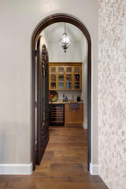 2510 Belaire E Ln, Granite Shoals, TX 78654 - hall featuring beverage cooler, arched walkways, wood finished floors, a sink, and baseboards
