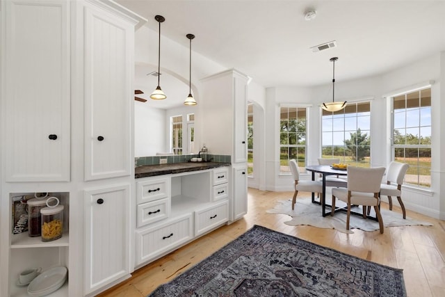 700 Longview Cir, Dripping Springs, TX 78620 - kitchen with plenty of natural light, arched walkways, and white cabinetry