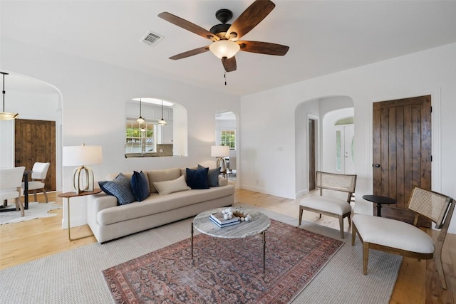 700 Longview Cir, Dripping Springs, TX 78620 - living room with arched walkways, ceiling fan, and light wood-style flooring