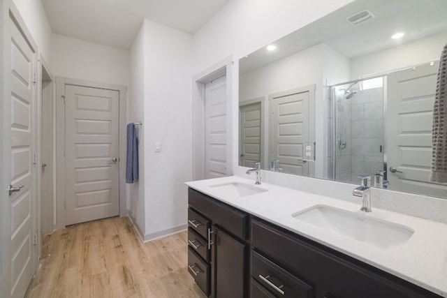 7812 City Top Blvd, Austin, TX 78724 - bathroom with a stall shower, double vanity, wood finished floors, and recessed lighting