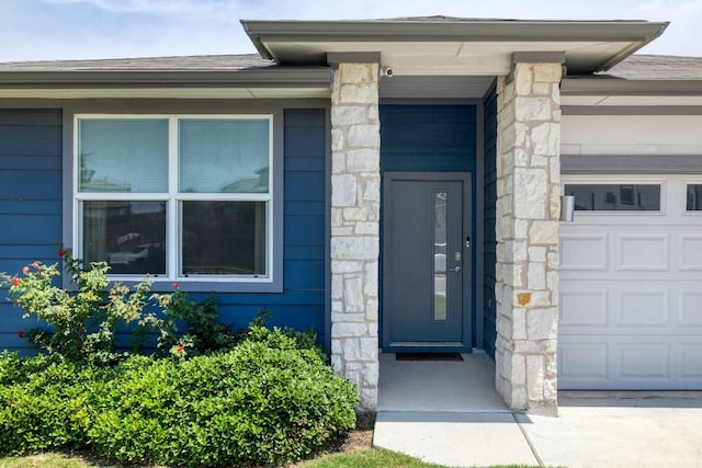 7812 City Top Blvd, Austin, TX 78724 - property entrance with stone siding, a shingled roof, and a garage
