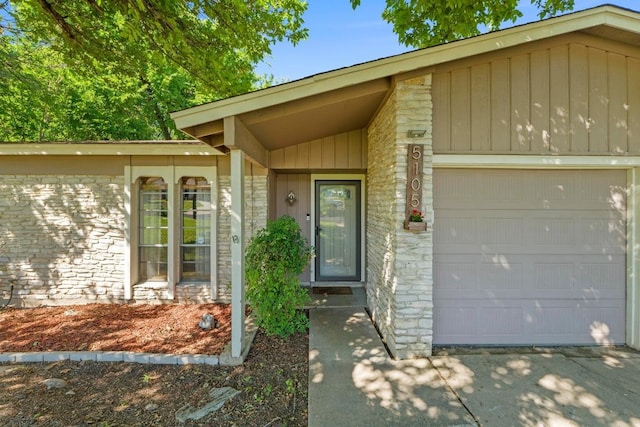 5105 Stone Gate Dr, Austin, TX 78721 - doorway to property featuring stone siding, a garage, and driveway