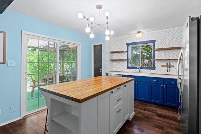 5105 Stone Gate Dr, Austin, TX 78721 - kitchen featuring open shelves, freestanding refrigerator, butcher block counters, and blue cabinets