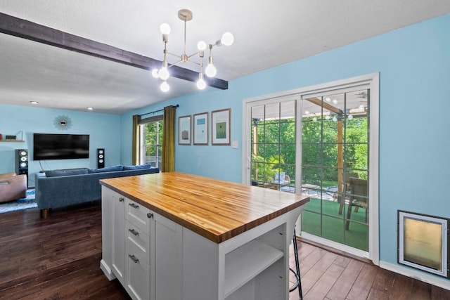5105 Stone Gate Dr, Austin, TX 78721 - kitchen featuring butcher block counters, dark wood-style floors, white cabinets, beamed ceiling, and decorative light fixtures