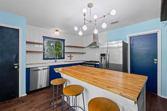 5105 Stone Gate Dr, Austin, TX 78721 - kitchen featuring stainless steel appliances, open shelves, wall chimney exhaust hood, a sink, and wooden counters