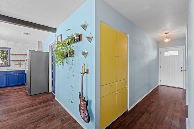 5105 Stone Gate Dr, Austin, TX 78721 - hallway with dark wood-type flooring, beam ceiling, baseboards, and a chandelier