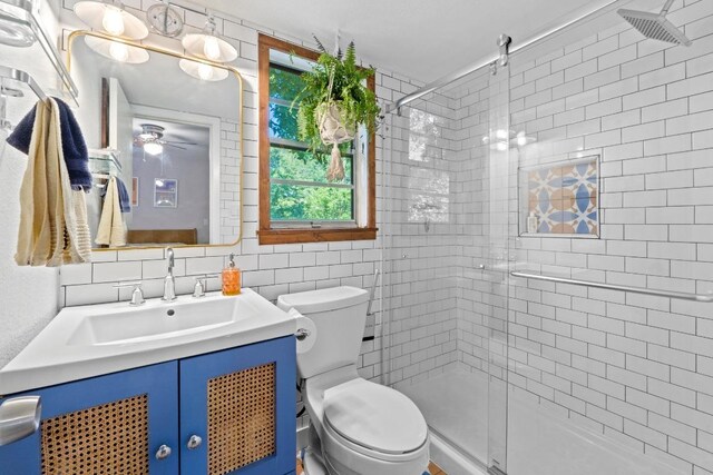 5105 Stone Gate Dr, Austin, TX 78721 - bathroom with a stall shower, vanity, and tile walls