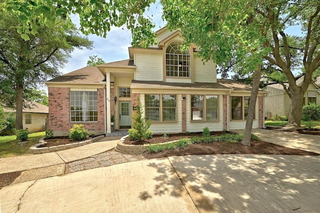 traditional-style home with brick siding and roof with shingles