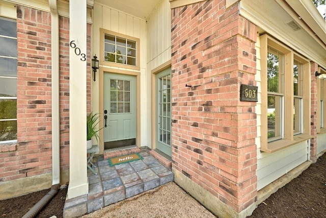 property entrance featuring brick siding and covered porch