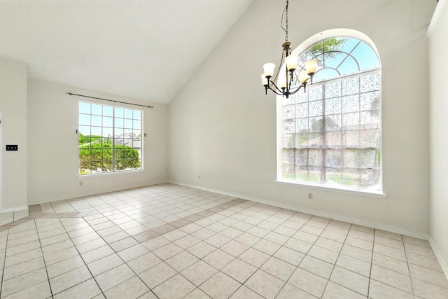 spare room featuring a chandelier, plenty of natural light, light tile patterned floors, and high vaulted ceiling