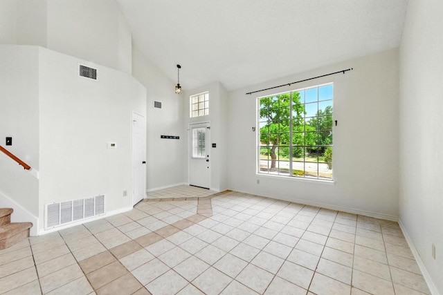 entryway with light tile patterned flooring, stairway, high vaulted ceiling, and baseboards